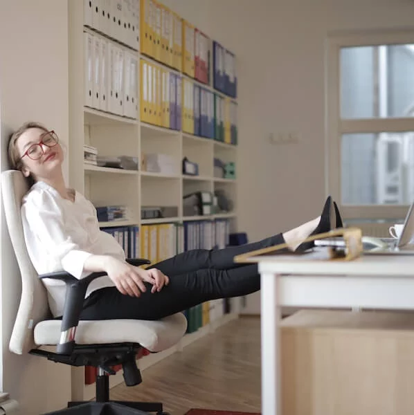 Relaxed woman sitting on a chair with her feet on the desk