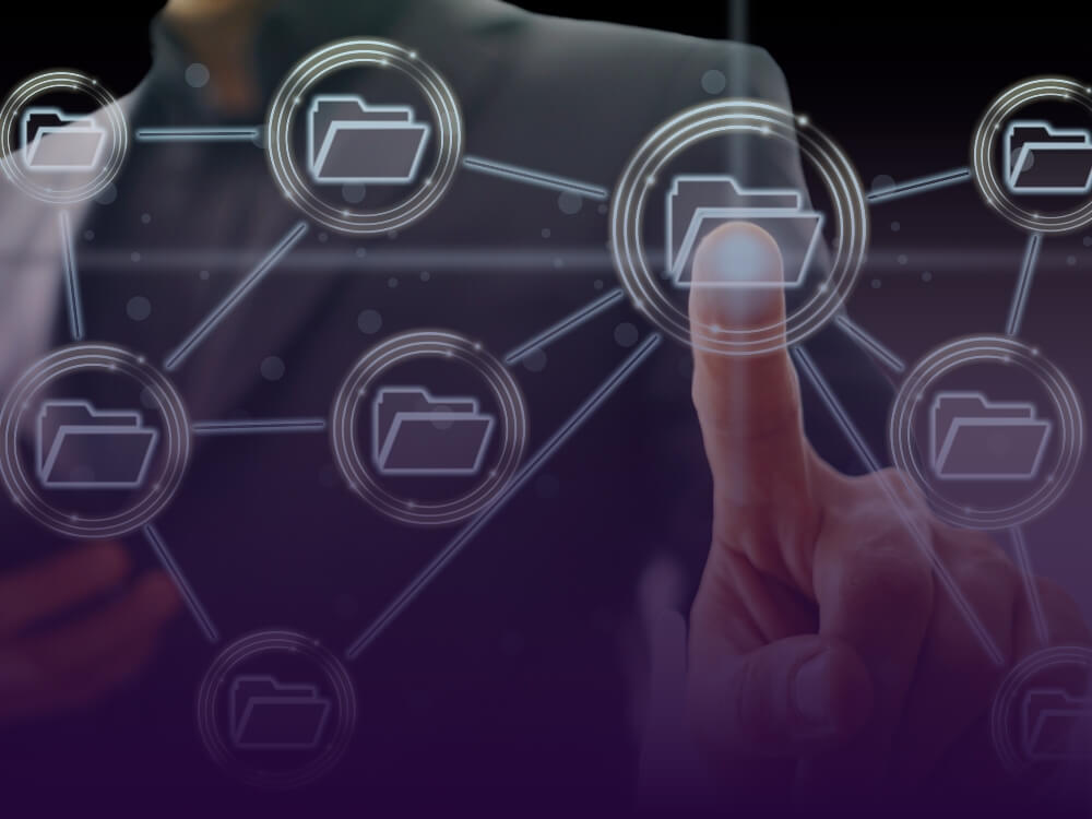 A hand with one finger pointing at a glass wall which depicts a network of folders.