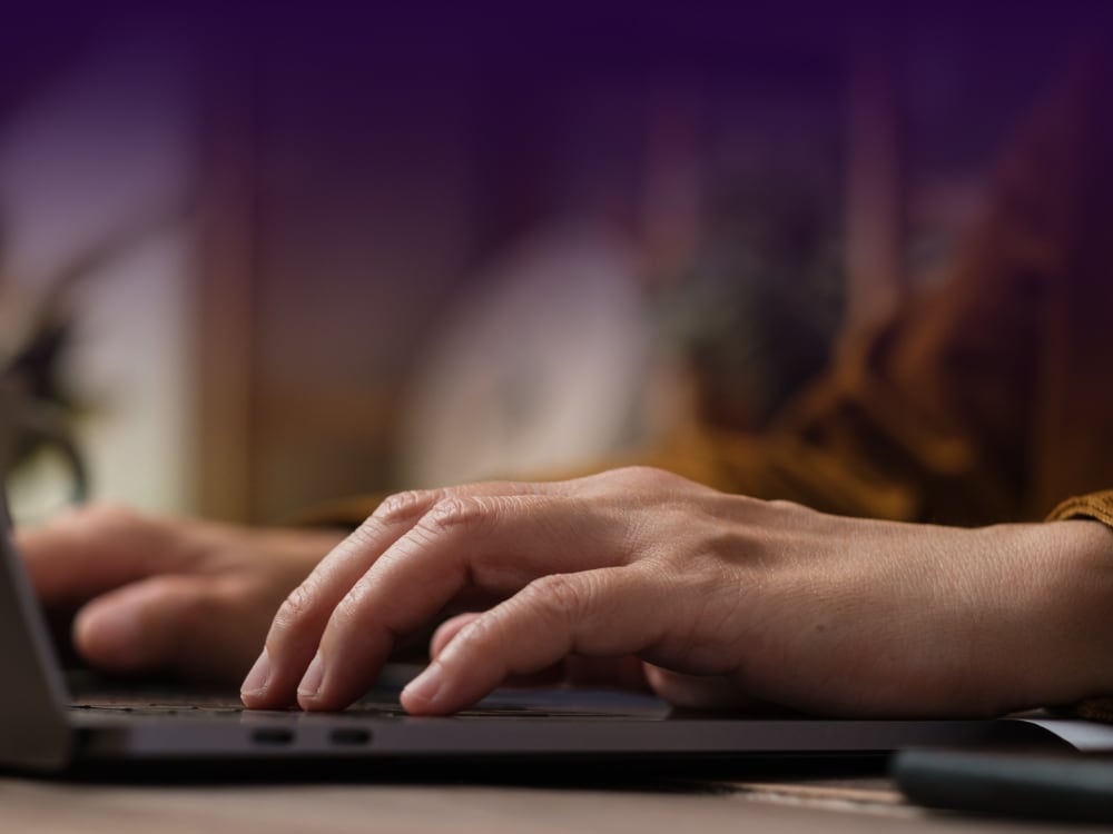 Close-up of hands typing on a laptop keyboard, representing the simplicity of performing a keyboard accessibility test.